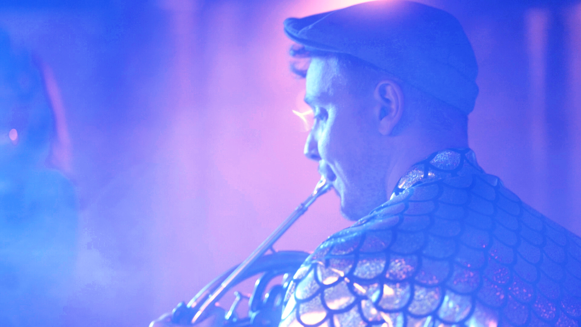 Andreas, corniste et co-directeur artistique d'Horizons Orchestra, jouant sur scène dans la fumée et les lumières